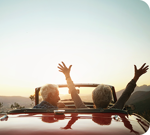mature-couple-in-convertible-at-sunset